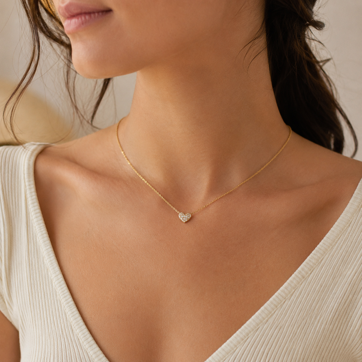 Woman wearing Kendra Scott Ari Pave Crystal Heart Necklace in gold with white CZ heart pendant