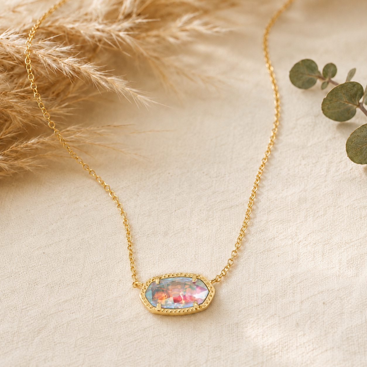 Kendra Scott Elisa Short Pendant Necklace in Gold Dichroic Glass with an iridescent oval pendant on a delicate gold chain