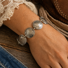 Genuine Domed Indian Heads & Tails Nickel Bracelet styled in a western-inspired flat lay with rustic decor and vintage character