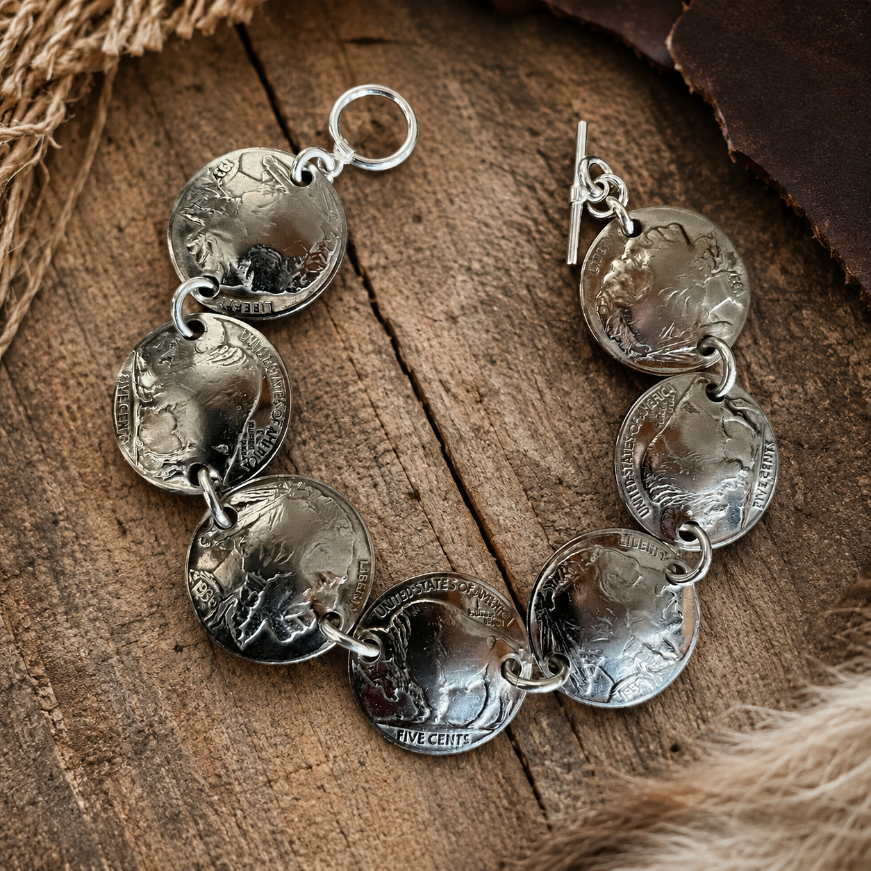 Genuine Domed Indian Heads & Tails Nickel Bracelet with sterling silver hardware displayed on a rustic wood surface.