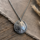 Genuine Indian Head nickel pendant necklace on an 18-inch chain, displayed on rustic fabric and wood.
