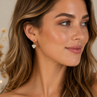 Kendra Scott Ari Heart Gold Dichroic Glass Huggie Earrings worn on model with iridescent heart charm detail