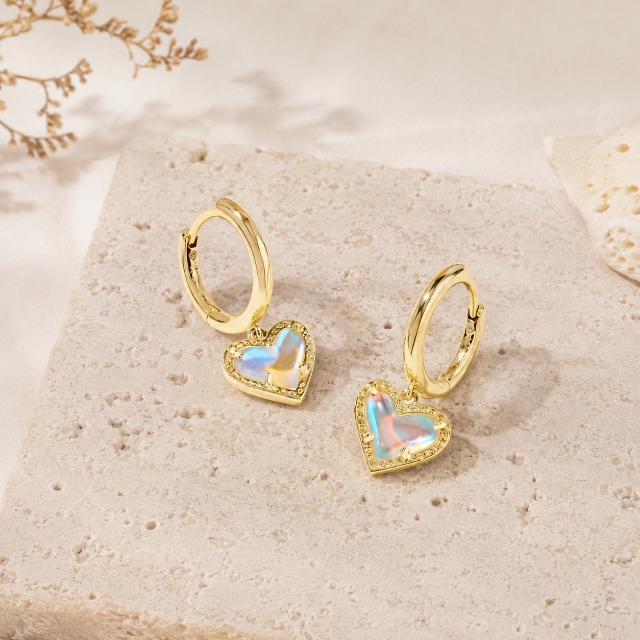 Kendra Scott Ari Heart Gold Huggie Earrings in Dichroic Glass with iridescent heart charms and hinge closure