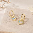 Kendra Scott Ari Heart Gold Huggie Earrings in Dichroic Glass with iridescent heart charms and hinge closure