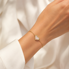 Kendra Scott Ari Heart Gold Iridescent Drusy bracelet worn on wrist with delicate chain