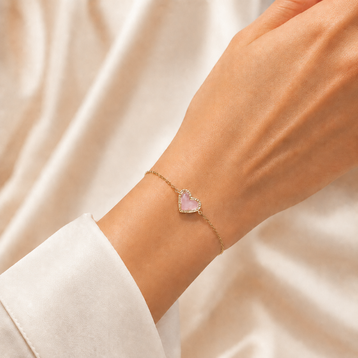 Kendra Scott Ari Heart Gold Rose Quartz bracelet worn on wrist with delicate chain
