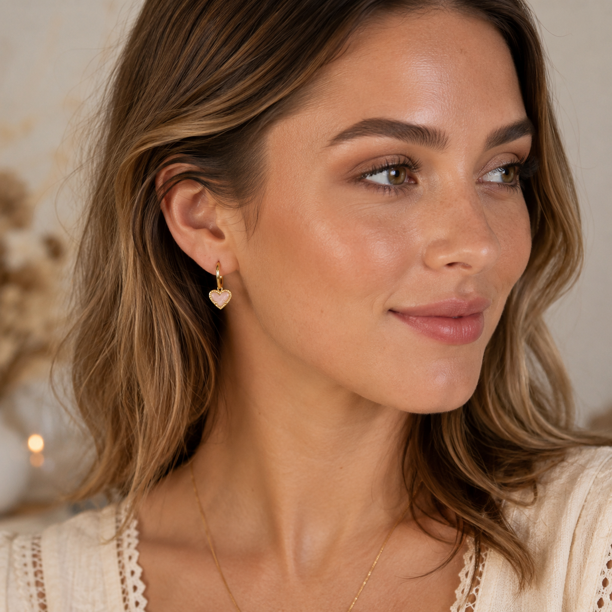 Kendra Scott Ari Heart Gold Rose Quartz Huggie Earrings worn on model with soft pink heart charm detail