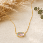 Kendra Scott Elisa Short Pendant Necklace in Gold Dichroic Glass with an iridescent oval pendant on a delicate gold chain