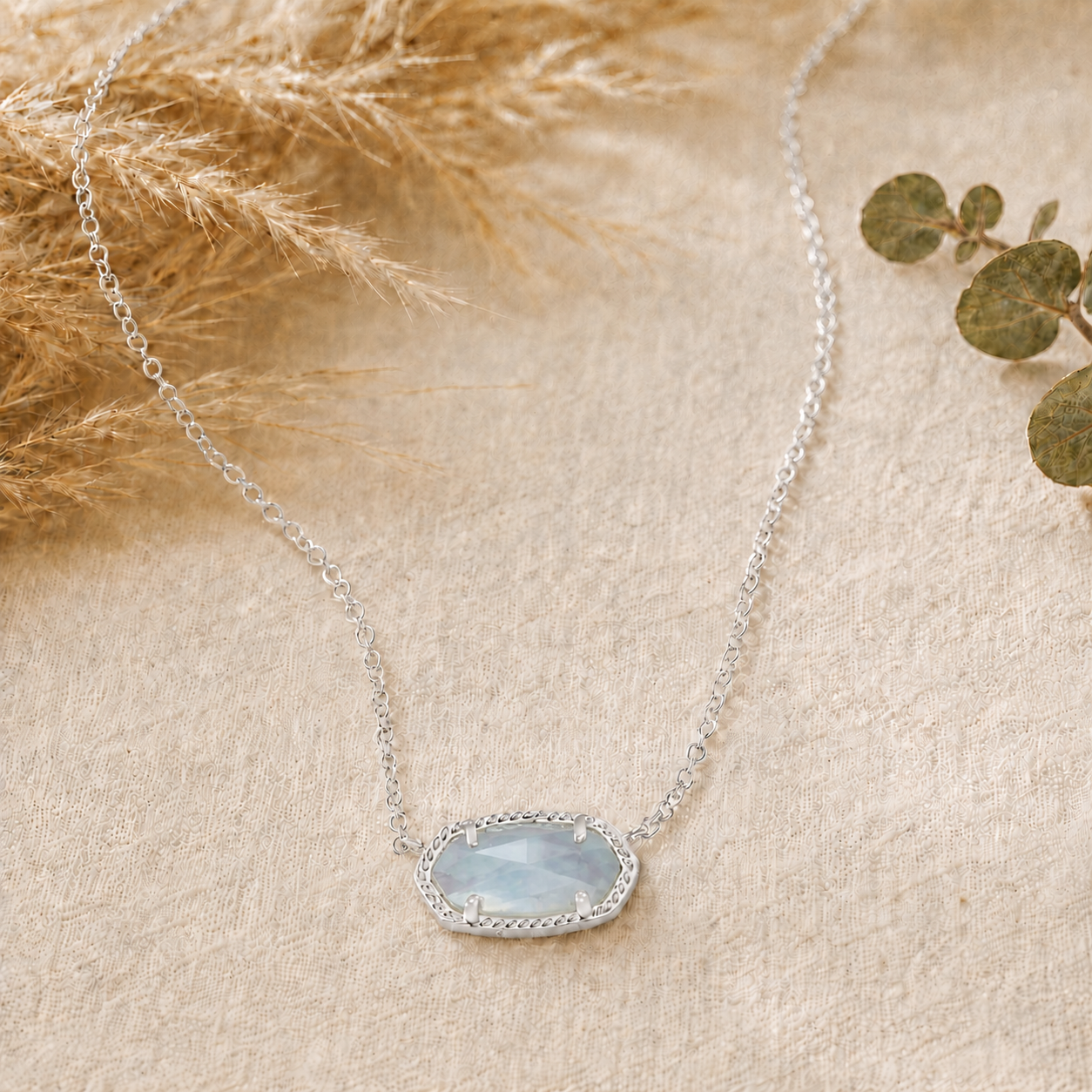 Kendra Scott Elisa Short Pendant Necklace in Rhodium Light Blue Illusion with a pale blue oval pendant on a delicate rhodium chain
