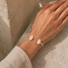 Kendra Scott Elton Cuff Bracelet in Rose Gold Dichroic Glass worn on wrist with iridescent oval stones